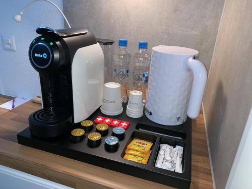 a coffee maker sitting on a shelf next to a coffee pot at Eh!Toi Self Motel in Etoy