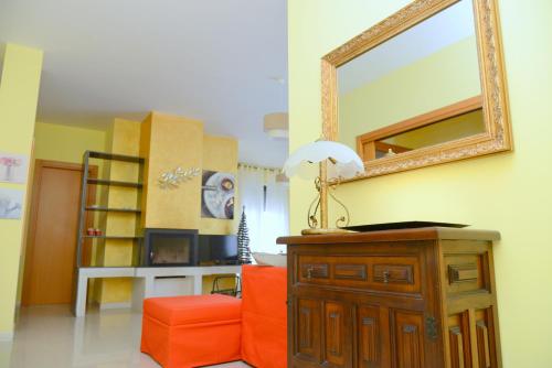 a living room with an orange chair and a mirror at "La casa di Mariagrazia" Appartamento 4 locali in Sammichele di Bari