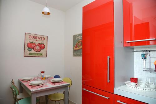 a kitchen with a red cabinet and a small table at "La casa di Mariagrazia" Appartamento 4 locali in Sammichele di Bari