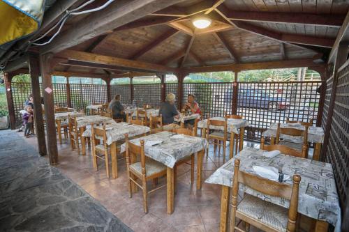 a restaurant with tables and chairs and people sitting at tables at Villaggio Camping Valdeiva in Deiva Marina