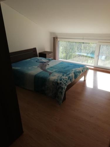 a bedroom with a bed and a large window at Florennes Gîte neuf 150 M2 devant un grand lac privé de 2 hectares poissonneux au milieu des bois in Florennes