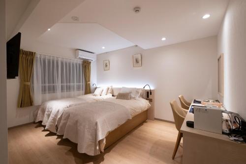 a bedroom with a bed and a desk with a computer at Studio Inn Nishi Shinjuku in Tokyo