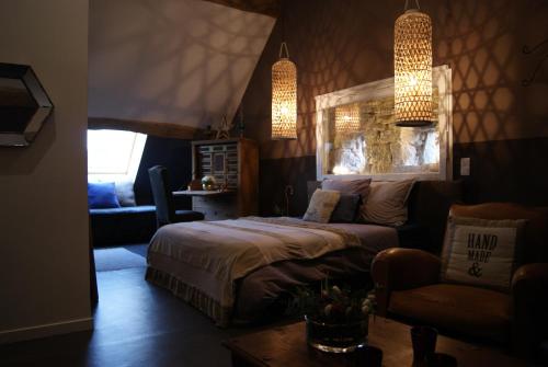 1 dormitorio con 1 cama, 1 sofá y 1 silla en De Pierre et de Lumière, en Jouhe