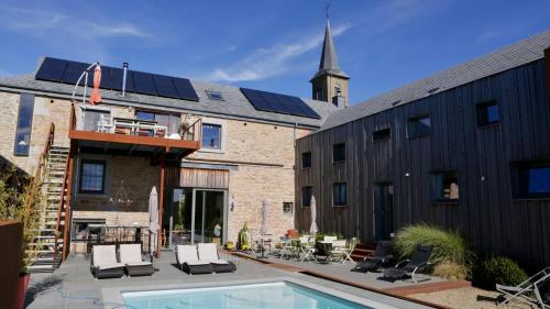 Havelange的住宿－Barsy 34，一座屋顶上设有太阳能电池板的建筑和一个游泳池