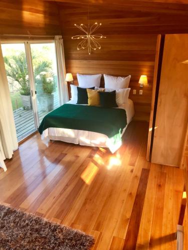 a bedroom with a bed in a room with wooden floors at Hjem Studios in La Pedrera