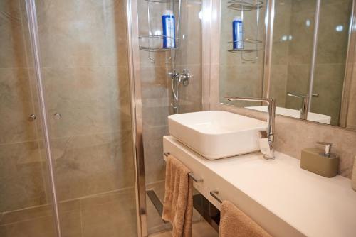 a bathroom with a sink and a shower at המקום של אורלי in Eilat