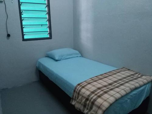 - un petit lit dans une chambre avec fenêtre dans l'établissement Homestay Sri Awana, à Alor Setar