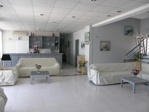 a living room with two couches and two tables at Megim Hotel in Palaiochóra