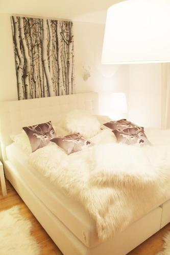 a white bed in a bedroom with a lamp at Haus Sonnenhang in Lam