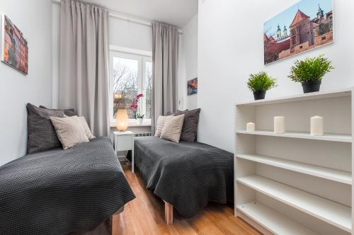 a bedroom with two beds and a window at Nowy Świat Cozy Apartment Warsaw by Renters in Warsaw