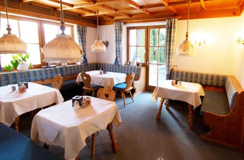 a dining room with tables and chairs and windows at Kur- und Ferienhotel Haser in Oberstaufen