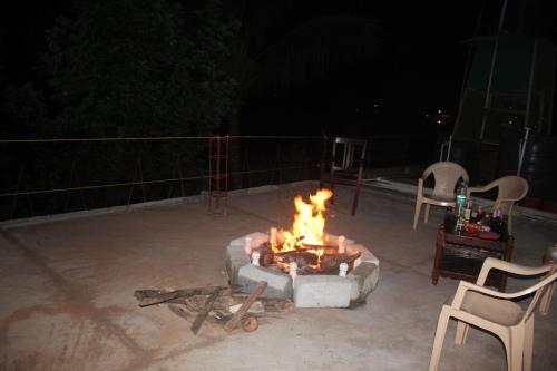 a fire pit on a patio at night at Chuppi Homestay in Madikeri