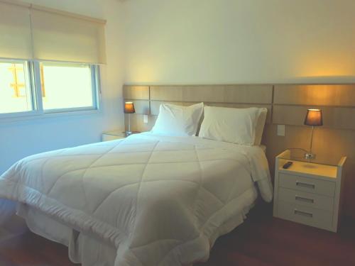 1 cama blanca grande en un dormitorio con 2 lámparas en Apartamento Boulevard, en Canela