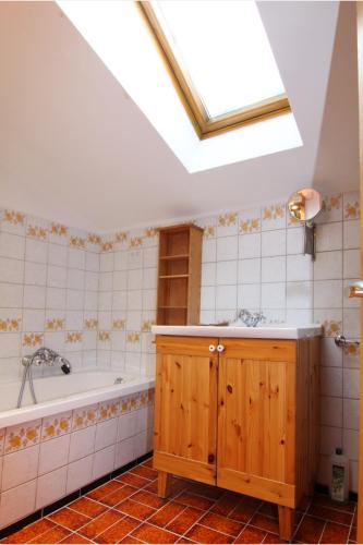 a bathroom with a tub and a sink and a skylight at Ferienwohnungen Oberau in Berchtesgaden