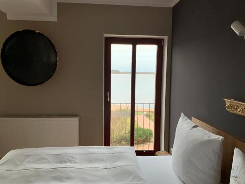 a bedroom with a bed and a window with a view at Hotel Inselhof in Malchow