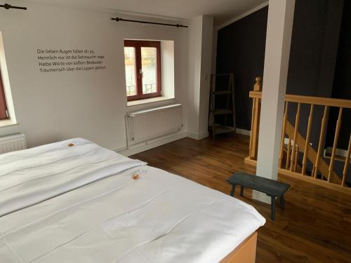 a bedroom with a white bed and a stair case at Hotel Inselhof in Malchow