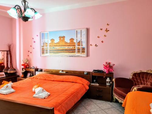 een slaapkamer met een oranje bed en een stoel bij 24 Cannoli in Leonforte