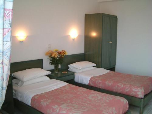 a hotel room with two beds and a cabinet at Stunning Seaview Town Apartment in Agios Nikolaos