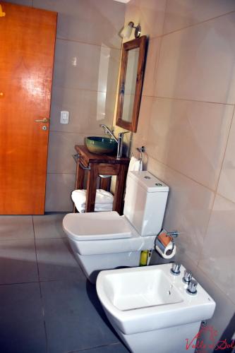a bathroom with a toilet and a sink at Posada Valle del Sol in Potrero de los Funes