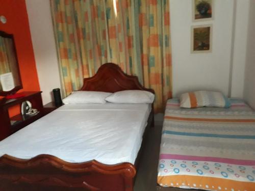 a small bedroom with two beds in it at Ludisa House in San Andrés