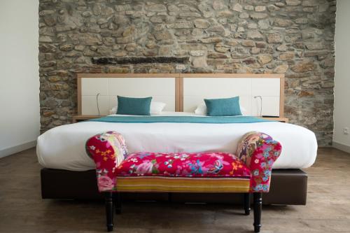 Hôtel de la Rhune في آسكا: غرفة نوم بسرير كبير وكرسي