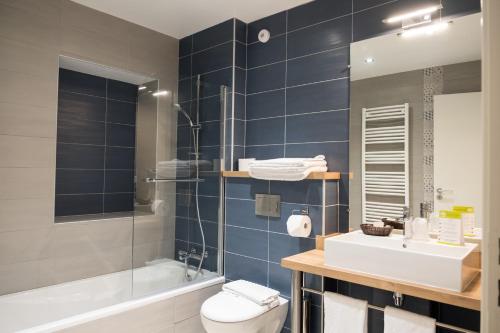 a bathroom with a toilet and a sink and a shower at Hôtel de la Rhune in Ascain