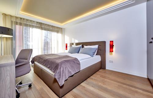 a bedroom with a bed and a desk and a chair at City Suites Murnau in Murnau am Staffelsee