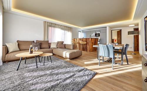 a living room with a couch and a table and chairs at City Suites Murnau in Murnau am Staffelsee