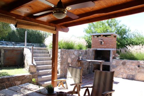 un patio con un muro in pietra e un forno a legna di Casa El Drago a La Cumbre