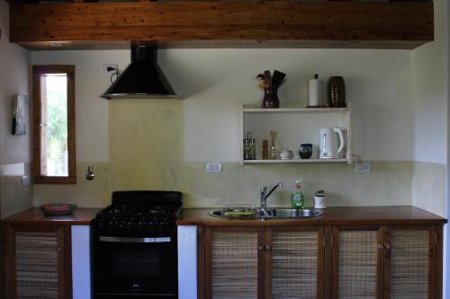 una cucina con fornelli e lavello di Casa El Drago a La Cumbre