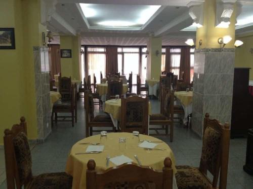 a dining room with tables and chairs in a restaurant at Hotel De L'aeroport in Alger