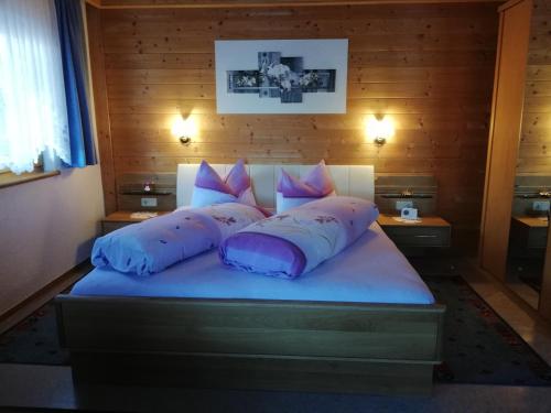 a bedroom with a bed with purple pillows at Ferienwohnung Außerlechner in Kartitsch