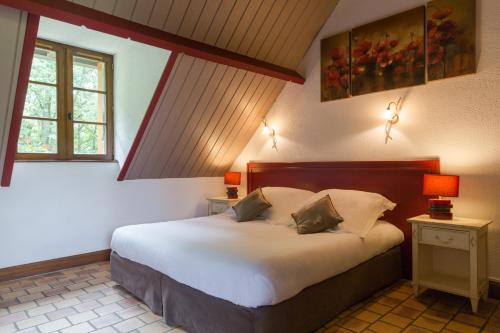 um quarto com uma grande cama branca num quarto em L'Orée des Chênes, The Originals Relais (Relais du Silence) em La Ferté-Saint-Aubin