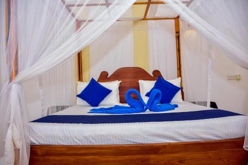 un letto con scarpe blu sopra di Ocean Gate Villa Tangalle a Tangalle