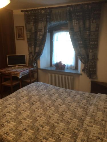 sypialnia z łóżkiem, oknem i biurkiem w obiekcie Affittacamere L'Abri w mieście Etroubles