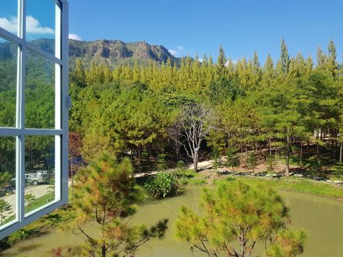 a window with a view of a river and trees at Villa PaSon in Khao Kho
