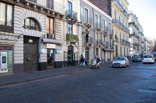 una calle con coches y una persona en una moto en Central Home Catania by Sicily in Home, en Catania