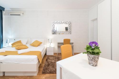 a bedroom with two beds and a table and a mirror at Villa Voinic 3 in Cavtat