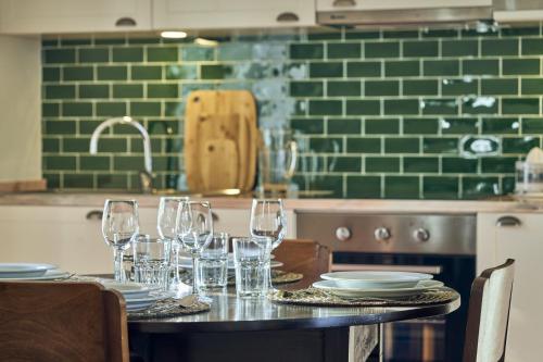 une table avec des verres et des assiettes dans une cuisine dans l'établissement Bordal Houses, à Funchal