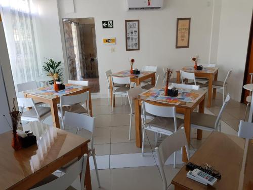 ein Esszimmer mit Tischen und weißen Stühlen in der Unterkunft Mamaloo Pousada in Maceió