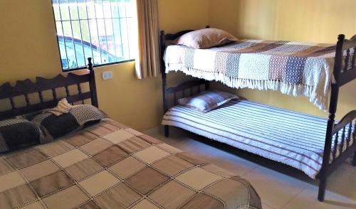 a bedroom with two bunk beds and a window at Casa Beira Mar in Jacumã