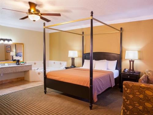 a bedroom with a four poster bed and a bathroom at Desert Quail Inn Sedona at Bell Rock in Sedona