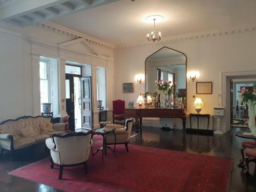 a living room with a table and a mirror at Longworth Hall Hotel in Hereford