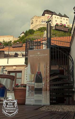 a sign with a bottle of wine and a glass at Hotel Pod Hradom in Trenčín