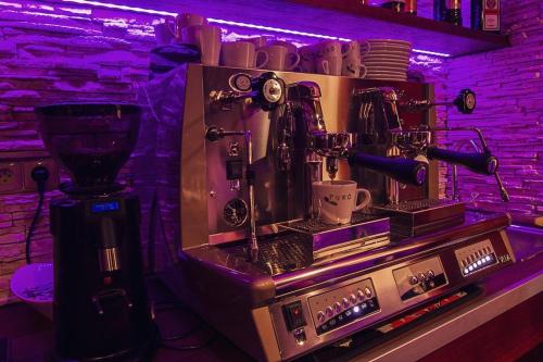 a coffee making machine in a room with purple lighting at Hotel Pod Hradom in Trenčín