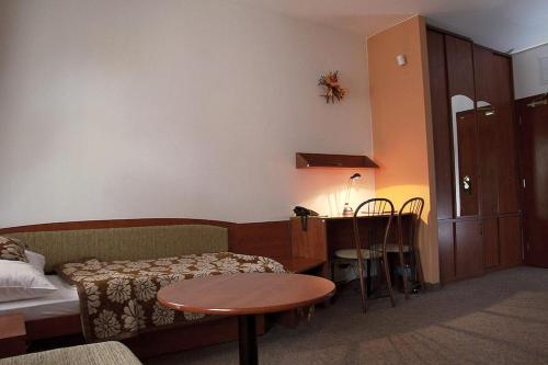 a room with a couch and a table and a desk at Hotel Pod Hradom in Trenčín