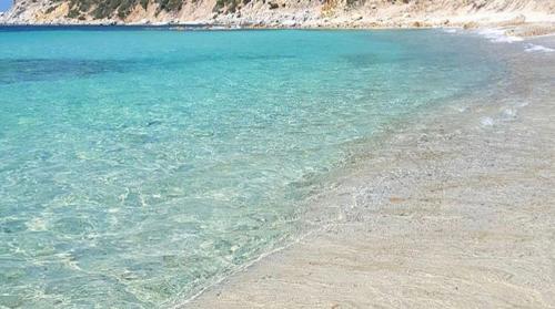 a beach with clear blue water and a sandy shore at Villa Sardinia Seaview&SPApool in Villasimius