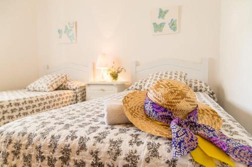 a bedroom with a bed with a straw hat on it at Can Agustín in Santa Gertrudis de Fruitera