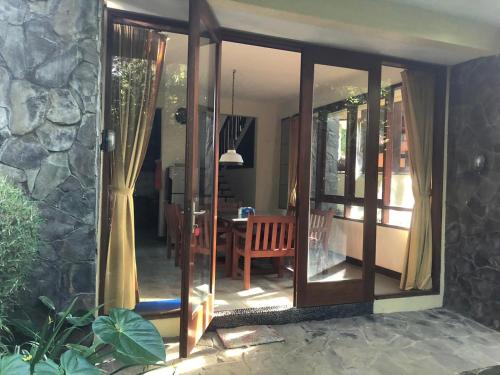 a sliding glass door to a patio with a table at Villa Klub Bunga, 3 BDR with kid's pool in Batu