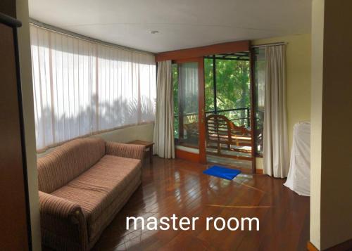 a living room with a couch and a large window at Villa Klub Bunga, 3 BDR with kid's pool in Batu